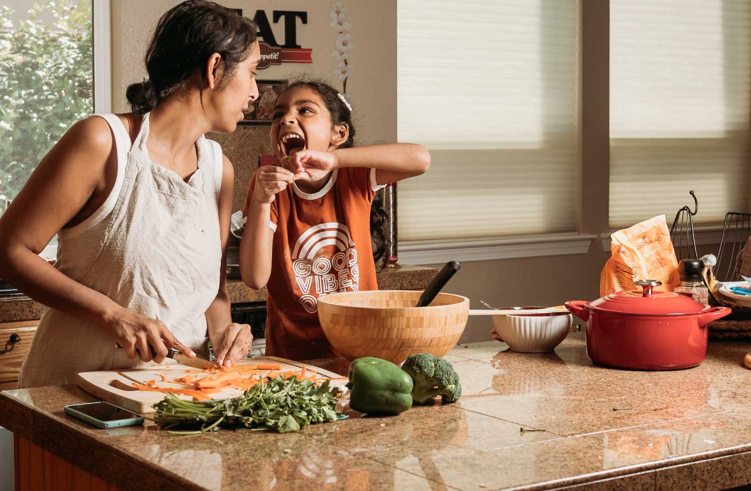 Fotografía de una señora y una niña cocinando juntas